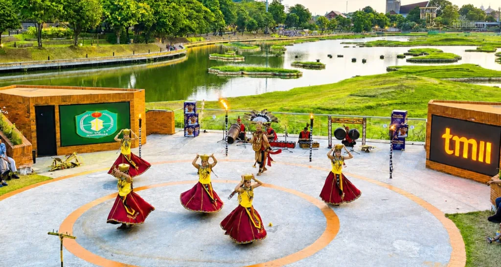 Penari perempuan membawakan tarian Pesta Gawai Dayak dengan kostum bernuansa kuning dan merah.