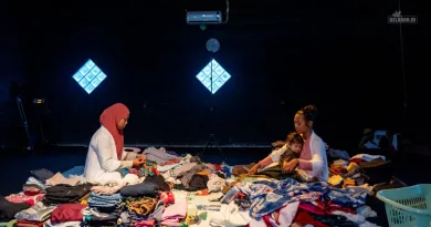 Amalia Rizqi dan Ericha Nurcholifatin melipat pakaian di tengah tumpukan baju dalam pertunjukan Tubuh Domestik: Mengurai Residu di Sakatoya Collective Space.